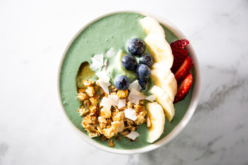 Spirulina yogurt with fruit in wooden bowl