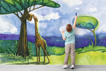 Cute little boy painting African savanna on wall