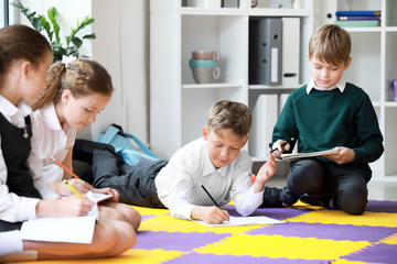 Cute little children doing lessons in classroom