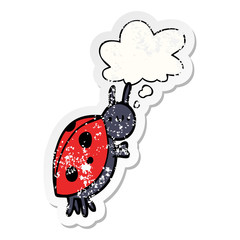 cartoon ladybug and thought bubble as a distressed worn sticker