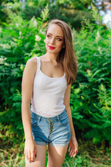 Young woman dressed in white shirt in summer park