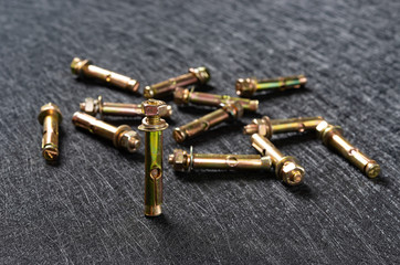 several expansion bolts on a dark background