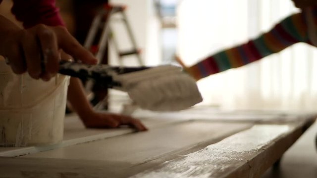 ドアのペンキを塗りなおす女性たち