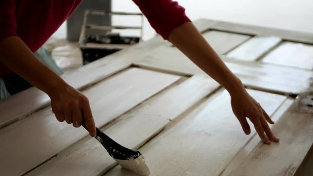 ドアのペンキを塗りなおす女性たち