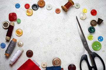 sewing accessories. scissors, thread, buttons on a light background