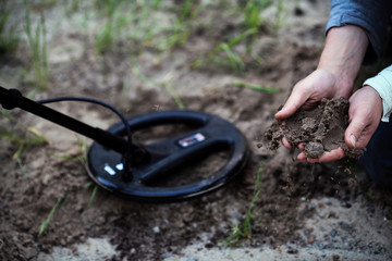 The treasure-hunters. Working with a metal detector.