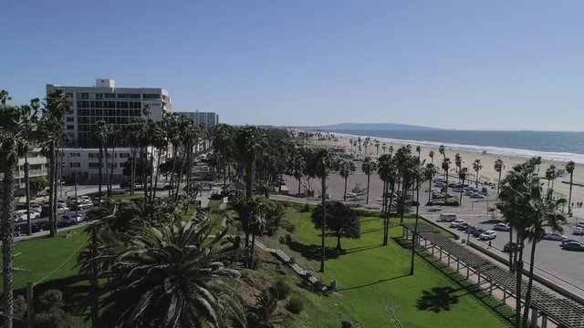 An aerial reveal of Santa Monica Beach, shorelines in Sunny California with a Rise and Rotate movement - 1080P 24P