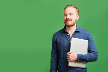 Cheerful professional software developer standing with laptop and smiling at camera, isolated on...