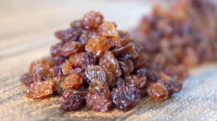 Dried raisins or kismis on wooden background.