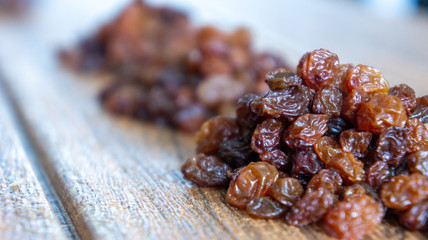 Dried raisins or kismis on wooden background.