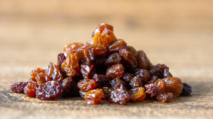 Dried raisins or kismis on wooden background.