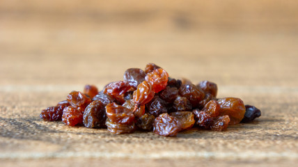 Dried raisins or kismis on wooden background.