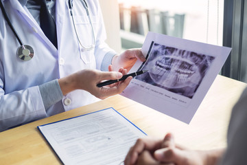Dental hygienist demonstrating and showing a dummy jaw to chack-up or healing teeth  patient.