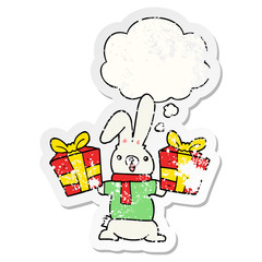 cartoon rabbit with christmas presents and thought bubble as a distressed worn sticker