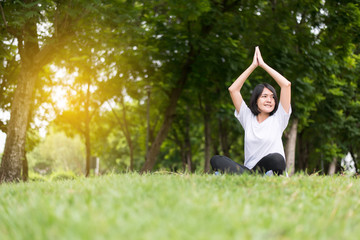 Fototapeta premium Asian woman practicing yoga at park in the morning,Happy and smiling,Positive thinking,Healthy and lifestyle concept