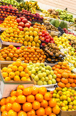 Large amount of fruits displayed in a market with many colors and variety