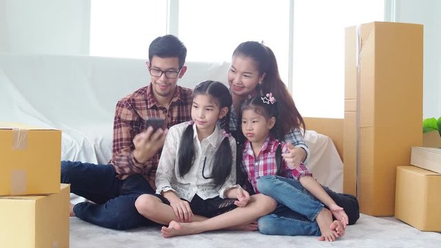 Asian family taking their photo by smart phone in new house