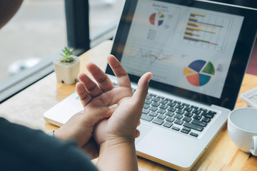 Young man holding his wrist close-up . Pain from using computer. Office syndrome hand pain by occupational disease.