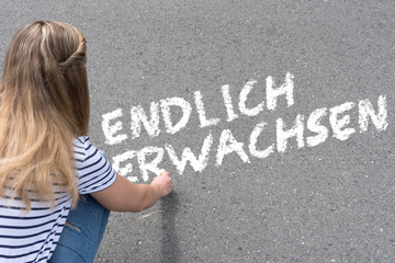 Ein junge Frau schreibt Endlich Erwachsen auf die Stra&szlig;e