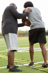 American Football coach training a young athlete.