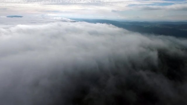 The Jura by drone, out of the clouds.