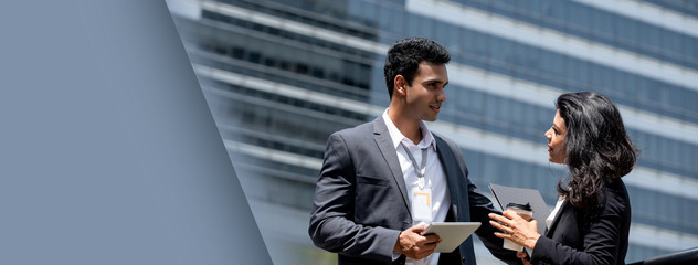 Indian businessman talking with businesswoman outdoors