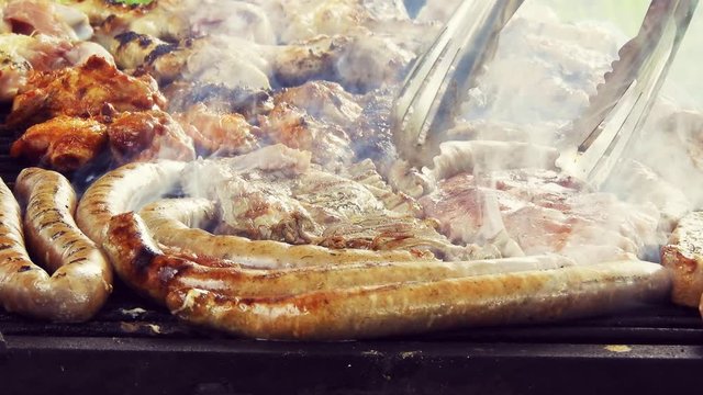 Grilled Sausage On The Flaming Grill. Bearbeque Outdoors with other meat on it, pork, chicken, mititei