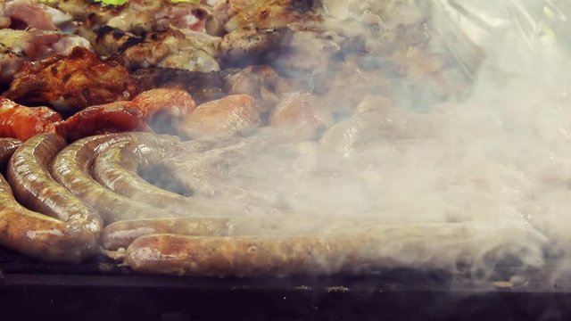 Grilled Sausage On The Flaming Grill. Bearbeque Outdoors with other meat on it, pork, chicken, mititei
