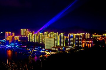 Obraz premium View of the night city of Sanya. Hainan Island, China. Neon lights of the night metropolis. Blur.