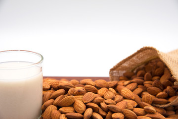 The seeds of many almonds placed with a glass of milk