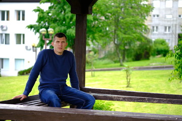 Fototapeta na wymiar Young stylish man sitting on a bench. Lifestyle Outdoor street photo