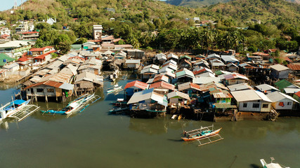 Fototapeta na wymiar Coron city with slums and poor district. Old wooden house standing on the sea in the fishing village. Houses of local poor people.Busuanga, Coron, Philippines. houses community standing in water in