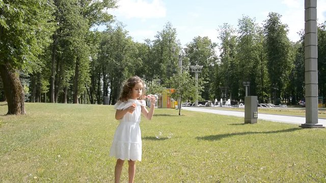 two little children girl and girl playing outdoors and blowing soap bubbles