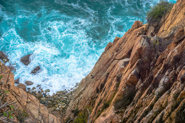 Blue sea at the bottom of a cliff
