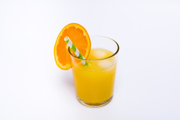 Orange juice in a glass with ice and paper straw on white background