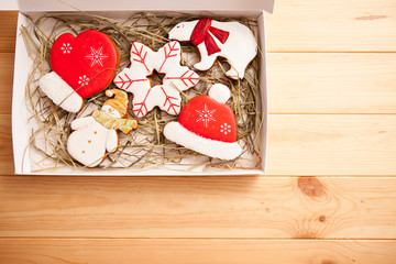 Christmas ginger bread - snowflake, mitten, hat, bear, snowman in box on light wooden background with copyspace. Top view, flat lay.