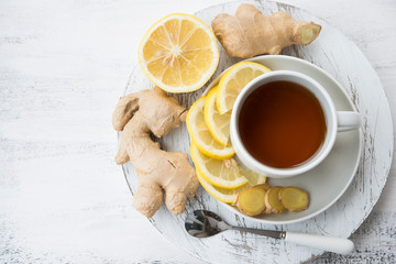 Cup of black tea with ginger and lemon on a light background.Top view.