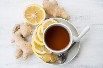 Cup of black tea with ginger and lemon on a light background.Top view.