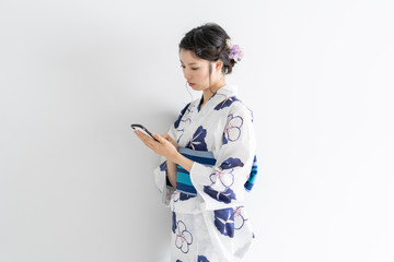 スマートフォンを使う浴衣の女性