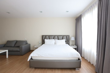 front view of new modern pearl and white bedroom with white bed and soft clear window light