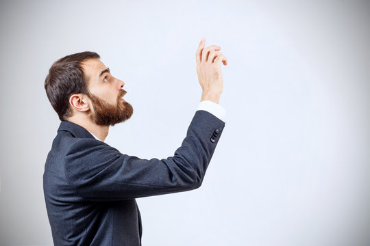 Businessman pointing to something or touching by forefinger.