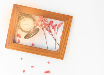 Beautiful pocket watch,pink dried flowers and wooden frame isolated on white background,top view