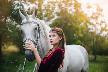 Beautiful girl in red medieval dress with unicorn. Fantasy. Woman Elf