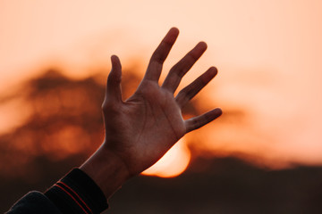 Hand in front of the sunset