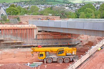 Mobile crane by a bridge under construction