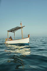 Obraz premium a father and a son sailing in a classic vintage boat