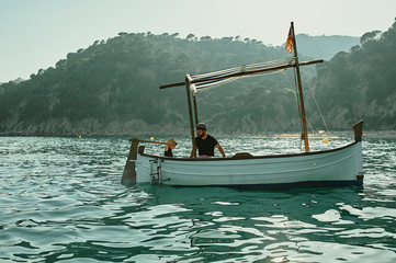 a father and a son sailing in a classic vintage boat