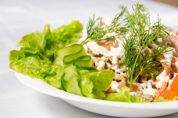 salad of boiled beef, champignons, carrots, pickled cucumbers, onions and lettuce seasoned with mayonnaise