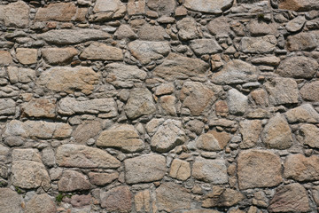 Old, rough, uneven stone wall of historic castle