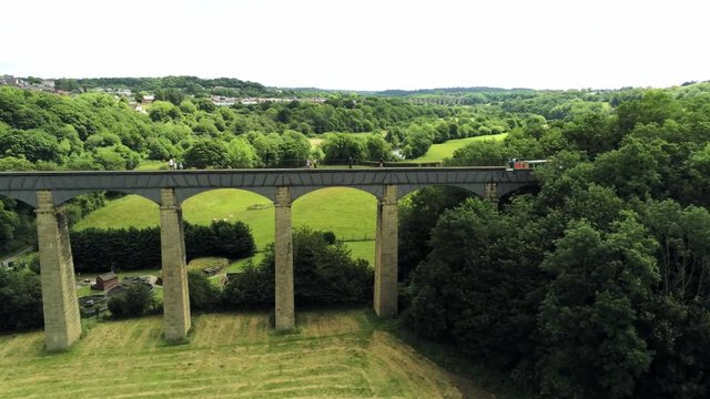 Pontcysyllte Aqueduct arch bridge canal waterway crossing. Aerial dolly watching boat cross bridge.